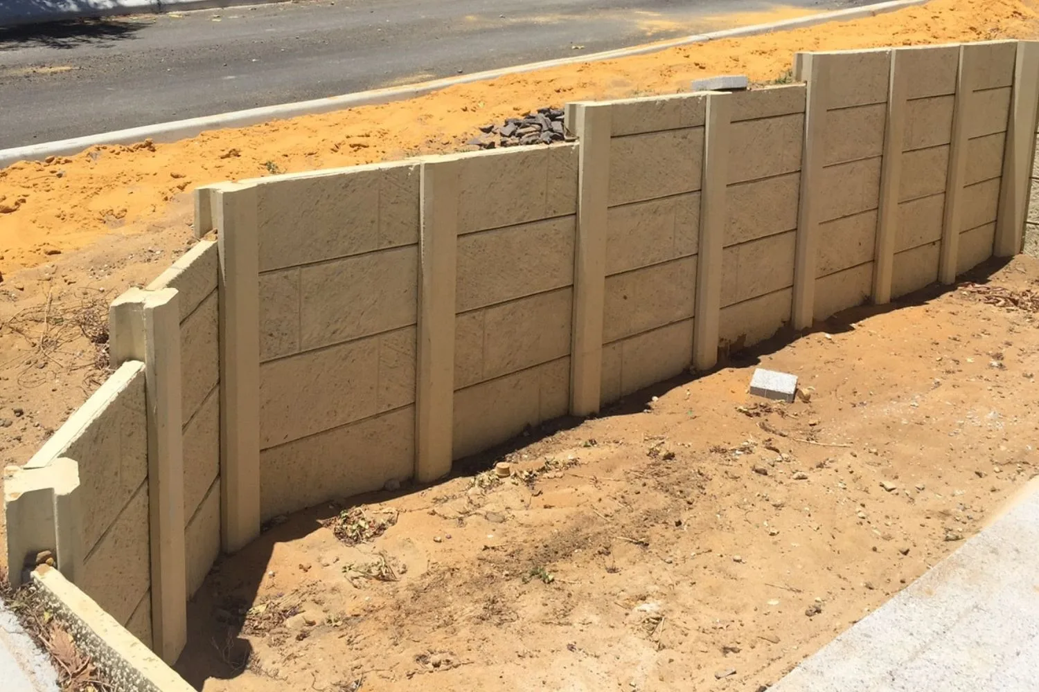 Concrete sleeper retaining wall installed on a freshly cut slope
