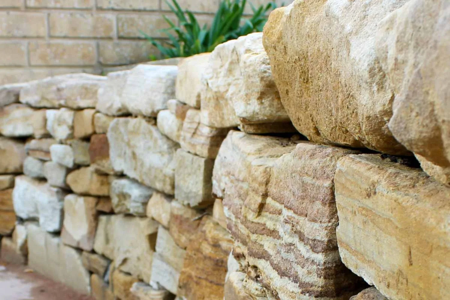 Close-up of stacked natural sandstone retaining wall blocks