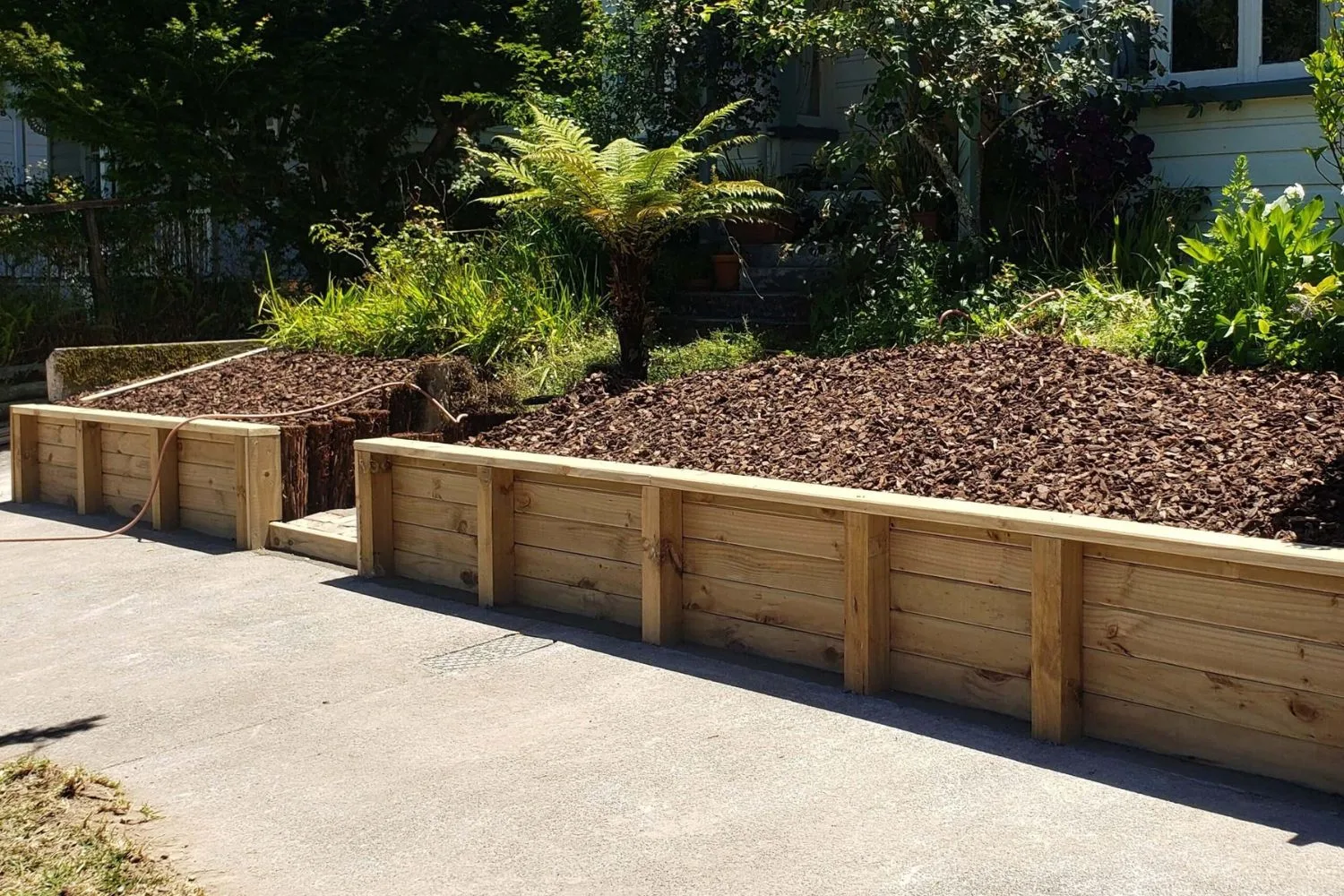 Two-tier timber sleeper retaining walls with mulched garden beds